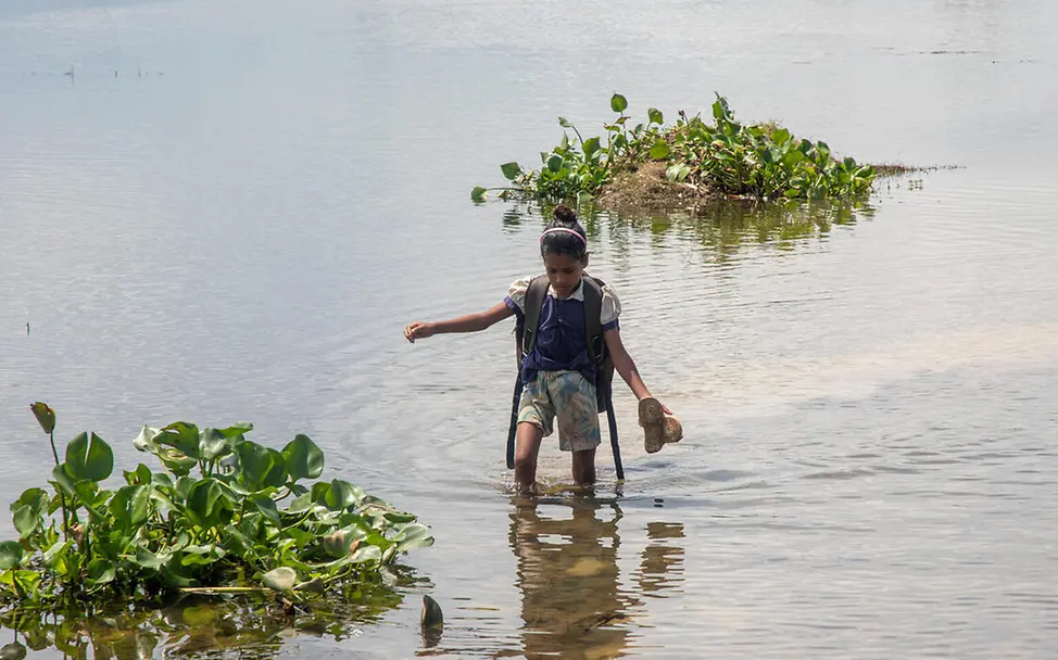 In Bangladesch haben es Kinder aus abgelegenen Regionen oft schwer, eine Schule zu erreichen. | © UNICEF/Satu Bildung in Bangladesch: Ein Mädchen watet allein durch knietiefes Wasser.