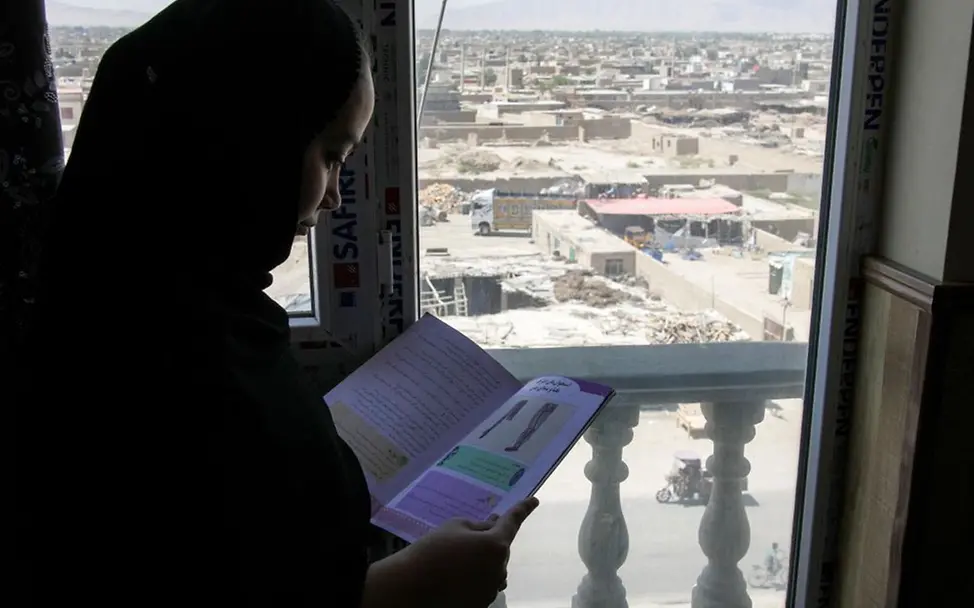 Ein Mädchen in Afghanistan liest in einem Schulheft. Sie darf nicht zur Schule gehen. © UNICEF/Karimi Afghanistan spenden: Ein 14-jähriges Mädchen liest in einem Schulheft.