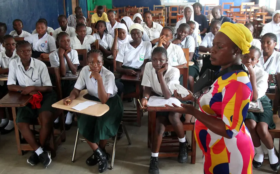 Spezielle Angebote für Mädchen stärken deren Selbstbewusstsein und vermitteln ihnen die Bedeutung von Bildung. | © UNICEF/Jallanzo Let Us Learn in Liberia: Eine Lehrerin spricht vor ihrer Klasse im Klassenzimmer.