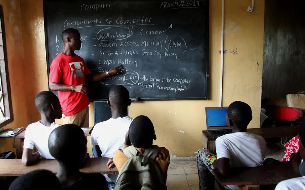 UNICEF unterstützt mit Let Us Learn verschiedene Ausbildungszentren für Jugendliche in Liberia. | © UNICEF/Jallanzo Let Us Learn in Liberia: Ein Lehrer steht an der Tafel und gibt Kindern Computerunterricht.