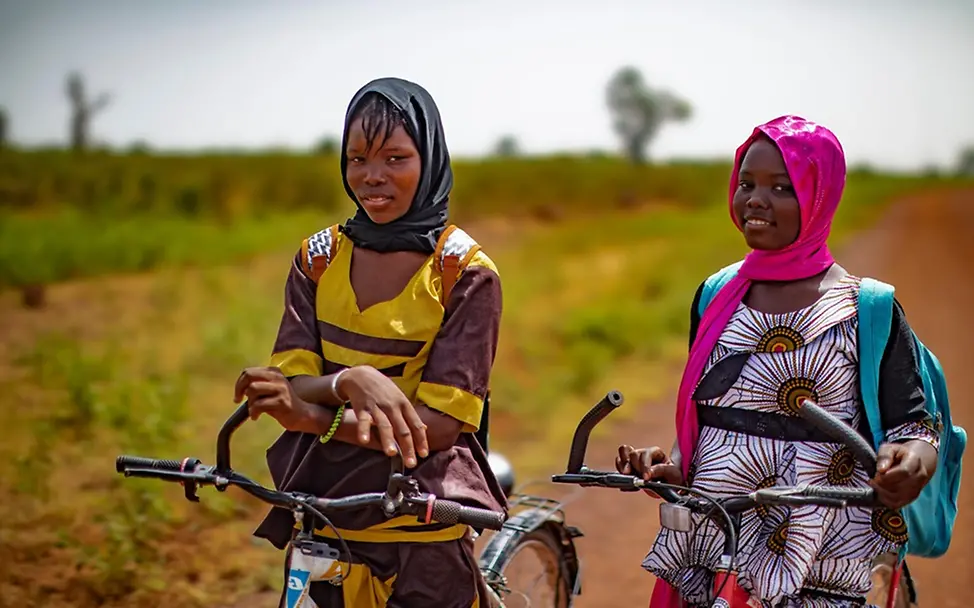 Hawa und Koumba (beide 15) radeln zu Schule. | © UNICEF/Dicko Weltmädchentag 2026: Hawa und Koumba (beide 15) radeln zu Schule.