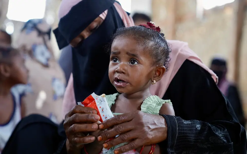 Hunger im Jemen: Ein Kind auf dem Schoß seiner Mutter wird mit Erdnusspaste gefüttert. 