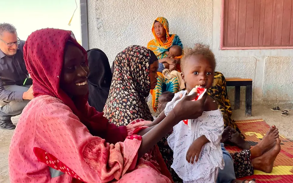 Eine Mutter mit Tochter in Mangelernährungszentrum | © Carla Magnanimo Eine Mutter gibt ihrem Kind therapeutische Nahrung im Sudan