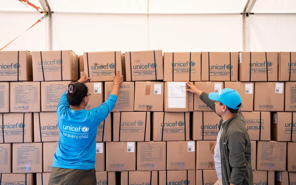 Nepal Sturzflut spenden: Zwei UNICEF-Mitarbeitende prüfen die im Katastrophengebiet angekommenen Hilfsgüter
