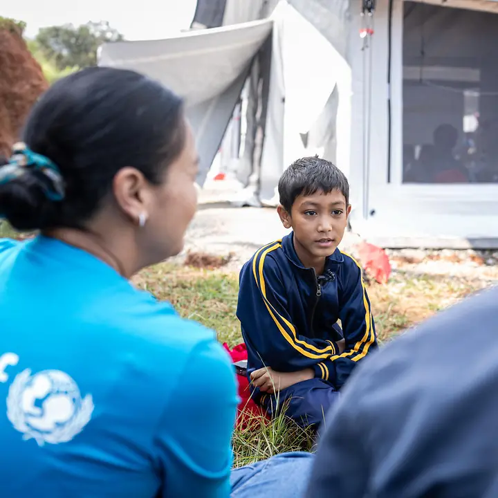 Nepal Sturzflut spenden: Ein Junge im Katastrophengebiet spricht mit einer UNICEF-Helferin