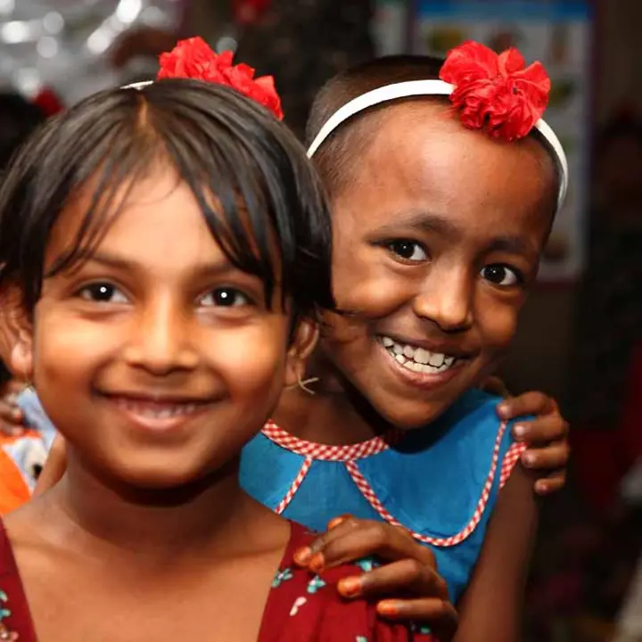 Die Bildungsinitiative Let Us Learn ermöglicht benachteiligten Kindern den Zugang zu Bildung. | © UNICEF/Kiron Bangladesch Let us learn: Zwei lächelnde Mädchen in einer Vorschulklasse.
